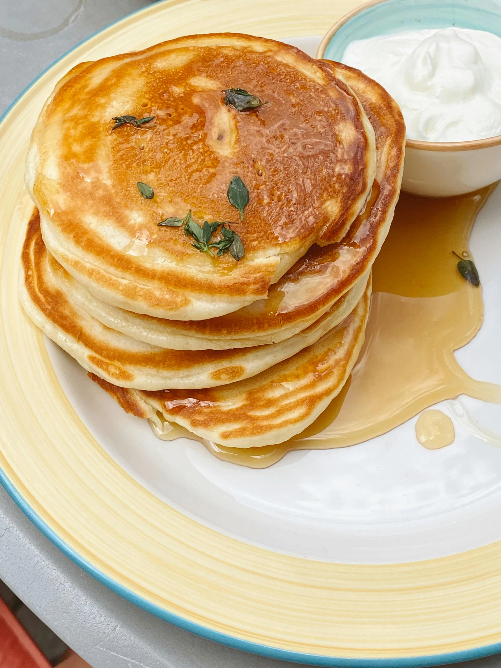 pancakes with er and syrup on a yellow plate