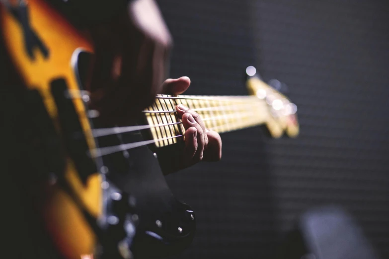 a close up of a person playing a bass guitar, pexels, coloured, thumbnail, profile shot, instagram picture
