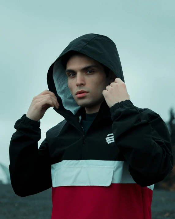 a man in red jacket holding his hands on his head