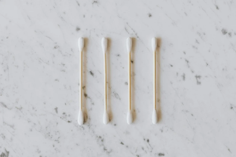 three toothbrushes sitting next to each other on a marble surface, by Nicolette Macnamara, minimalism, white smoke, earbuds, white sleeves, ignant