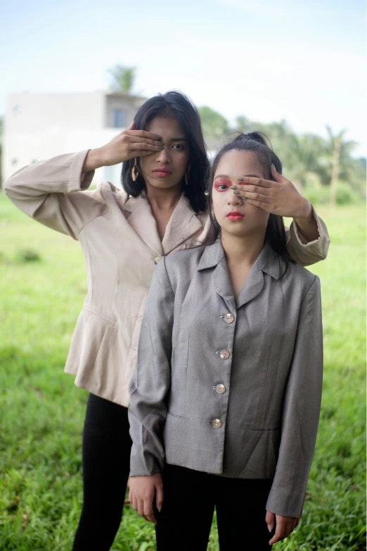 a couple of women standing on top of a lush green field, an album cover, inspired by Sasha Putrya, unsplash, realism, money sign pupils, indonesia, left eye stripe, military