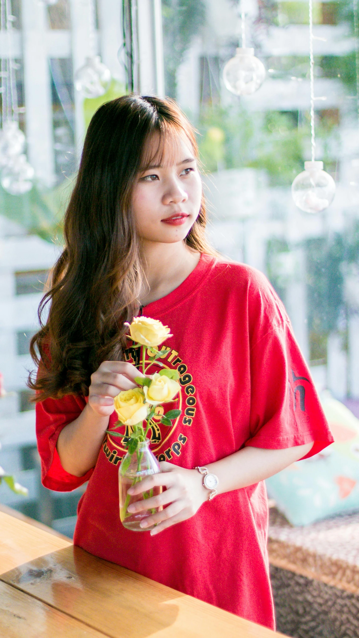 a woman holding a vase of flowers in front of a window, by Oka Yasutomo, pexels contest winner, pop art, red t-shirt, 1 8 yo, low quality photo, ulzzang