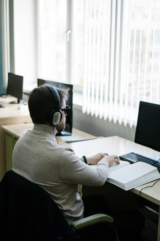 a man sitting at a desk in front of a laptop computer, headphones on, gamedesign, 2 5 6 x 2 5 6 pixels, photo of a classroom