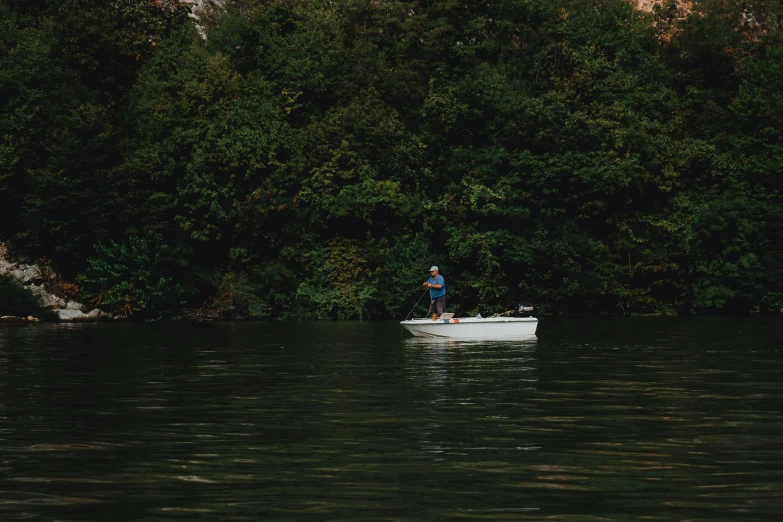 a person on a small boat in a body of water, fishing, alessio albi, sydney hanson, lush surroundings