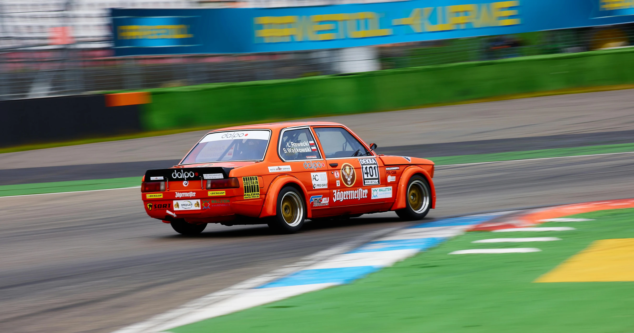 an orange race car driving down the track