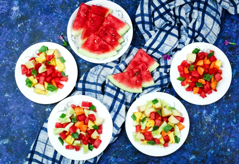 a number of plates of food on a table, by Julia Pishtar, watermelon, blue and red tones, listing image, salad