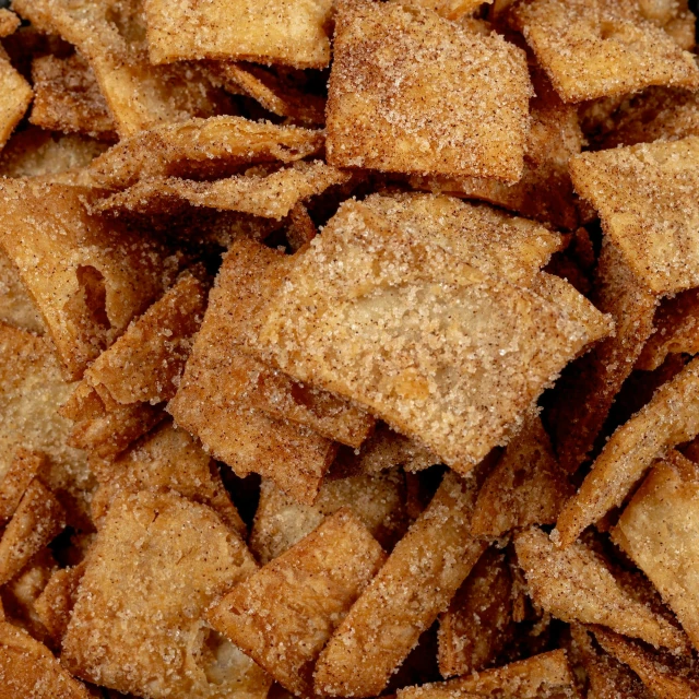 a pile of sugared crackers sitting on top of a table, by Mike Bierek, close-up from above, squares, cinnamon, nachos