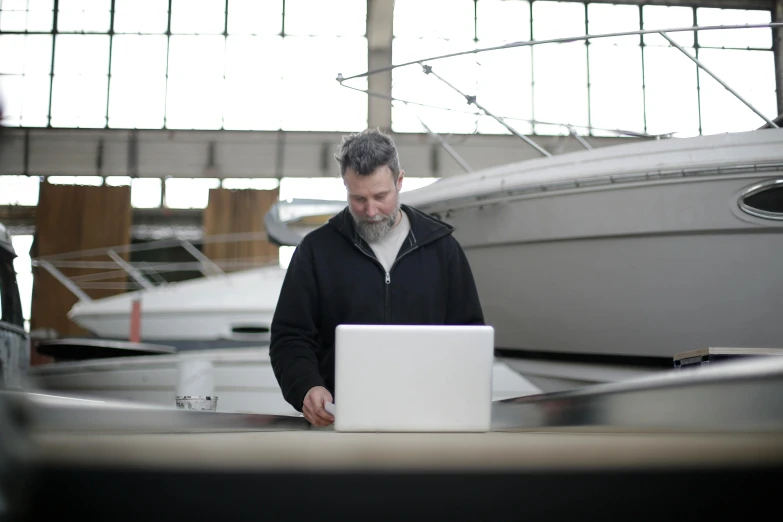 a man standing in front of a laptop computer, by John Murdoch, unsplash, boat, inspect in inventory image, ignant, paul bonner