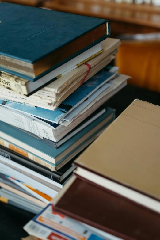 a stack of books sitting on top of a table, unreadable, curated collections, reddit post, cinematic still
