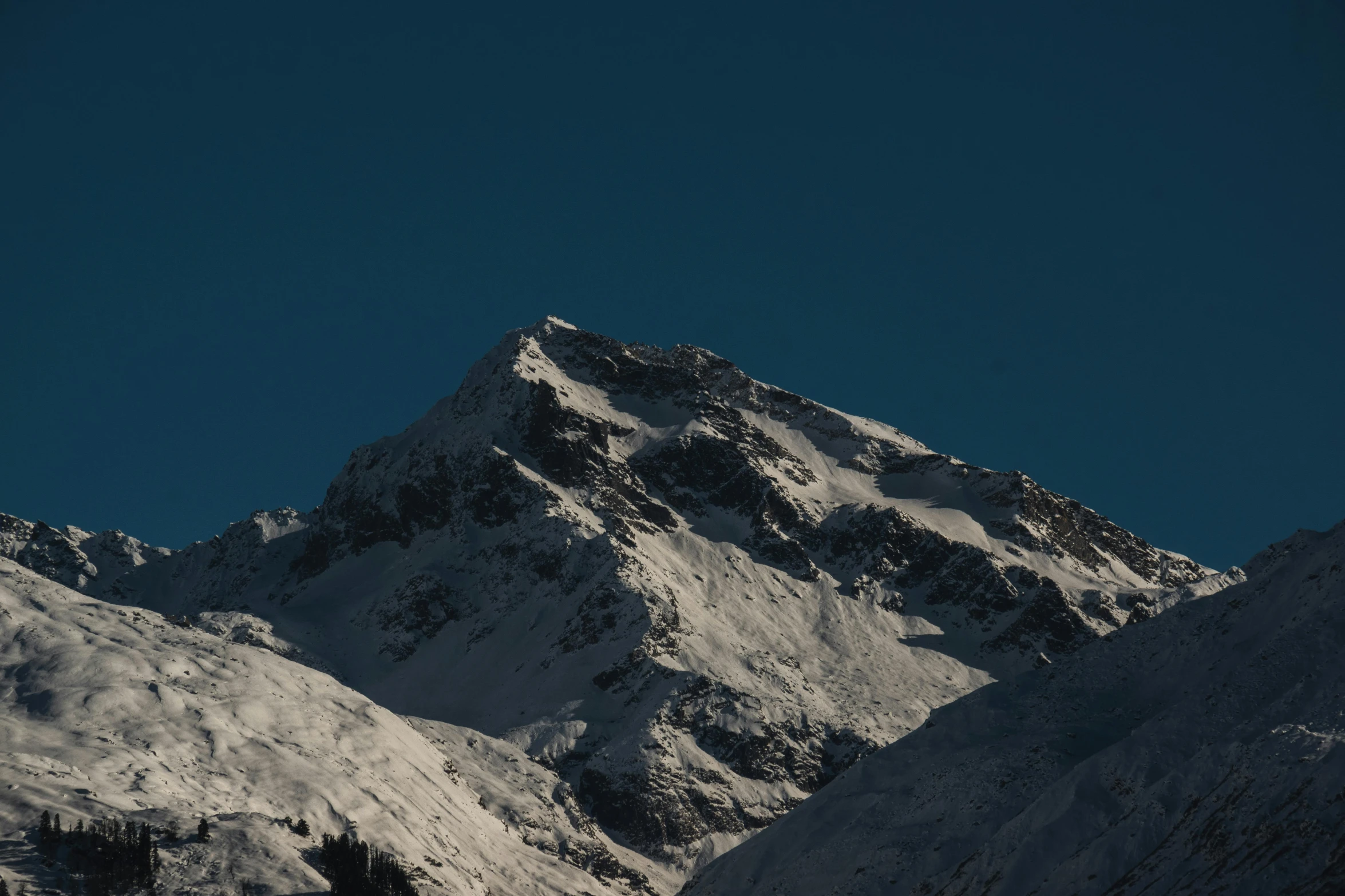 the mountain that is covered in snow on a sunny day