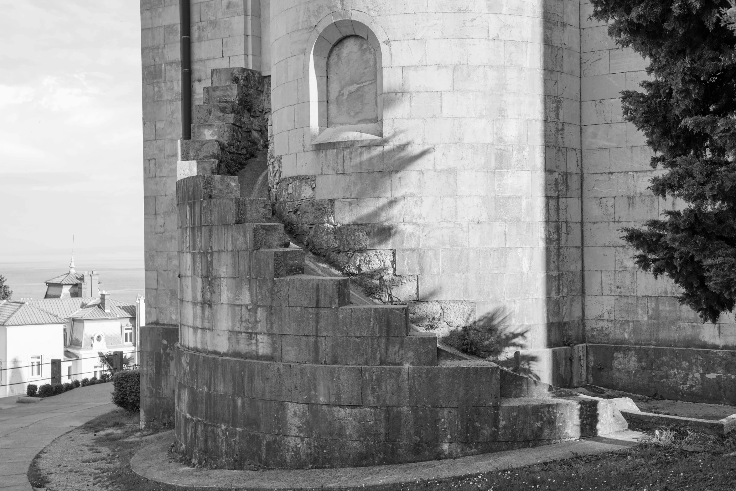 a black and white photo of a clock tower, a black and white photo, by Jan Rustem, romanesque, spiralling bushes, fibonacci composition, contre jour, near the sea