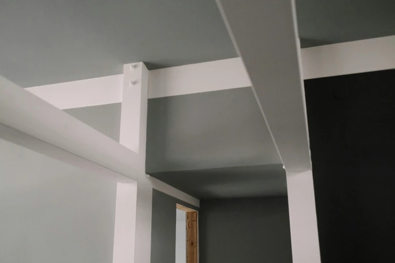 a room with gray walls and white beams, unsplash, articulated joints, close up shot from the side, detailed product image, colour photo