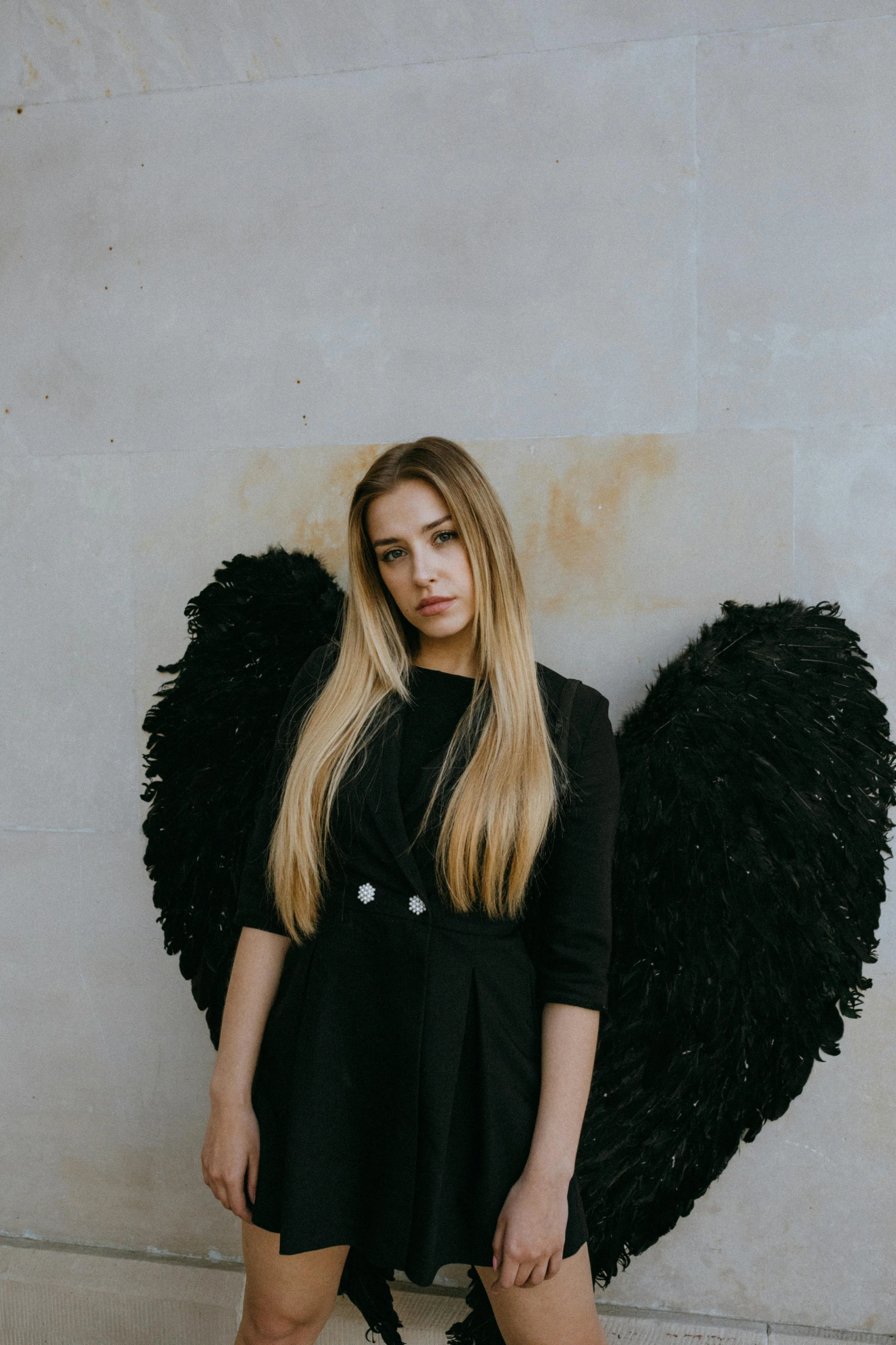 a woman standing in front of a wall with wings, pexels contest winner, baroque, casual black clothing, sydney sweeney, teenager, cupid