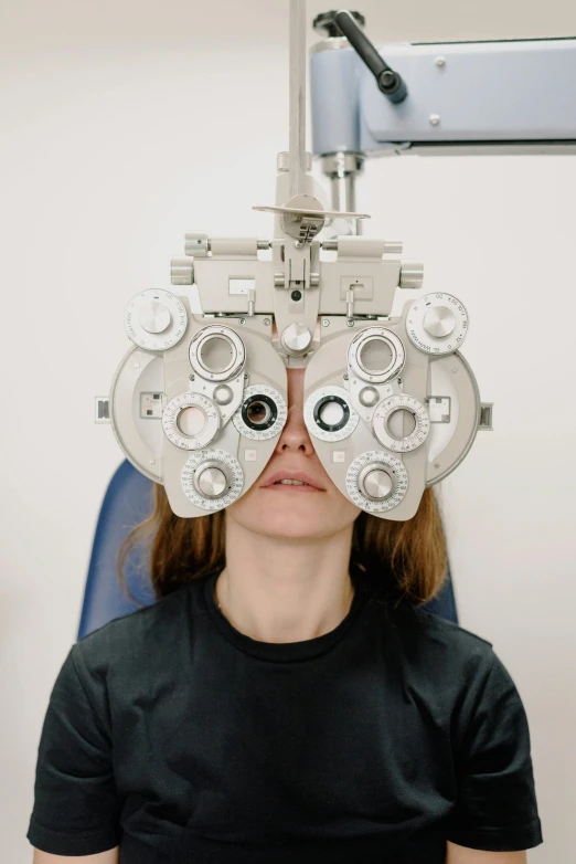 a woman with a pair of glasses on her head, by Adam Marczyński, unsplash, hyperrealism, on an operating table, metal eye piece, photographed for reuters, highly symmetrical