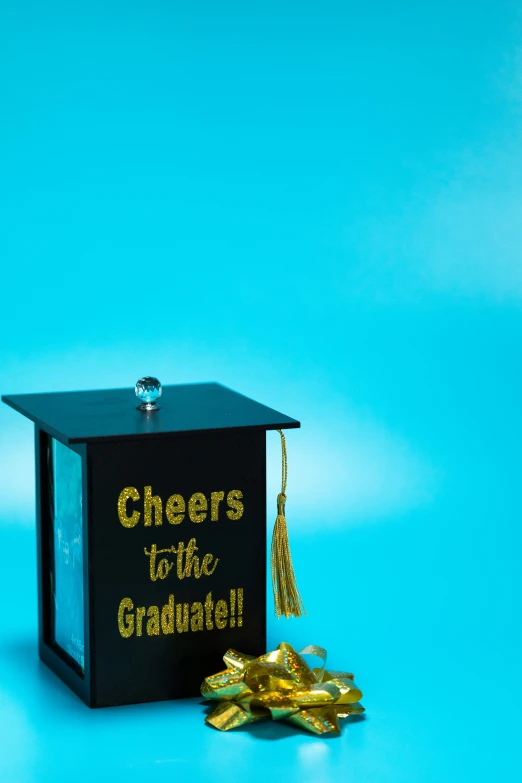 a graduation cap sitting on top of a box, a portrait, pexels contest winner, happening, gumball machine, black, cheers, square