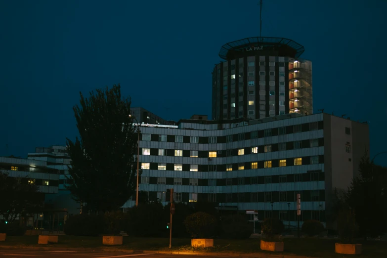 a tall white and grey building lit up at night