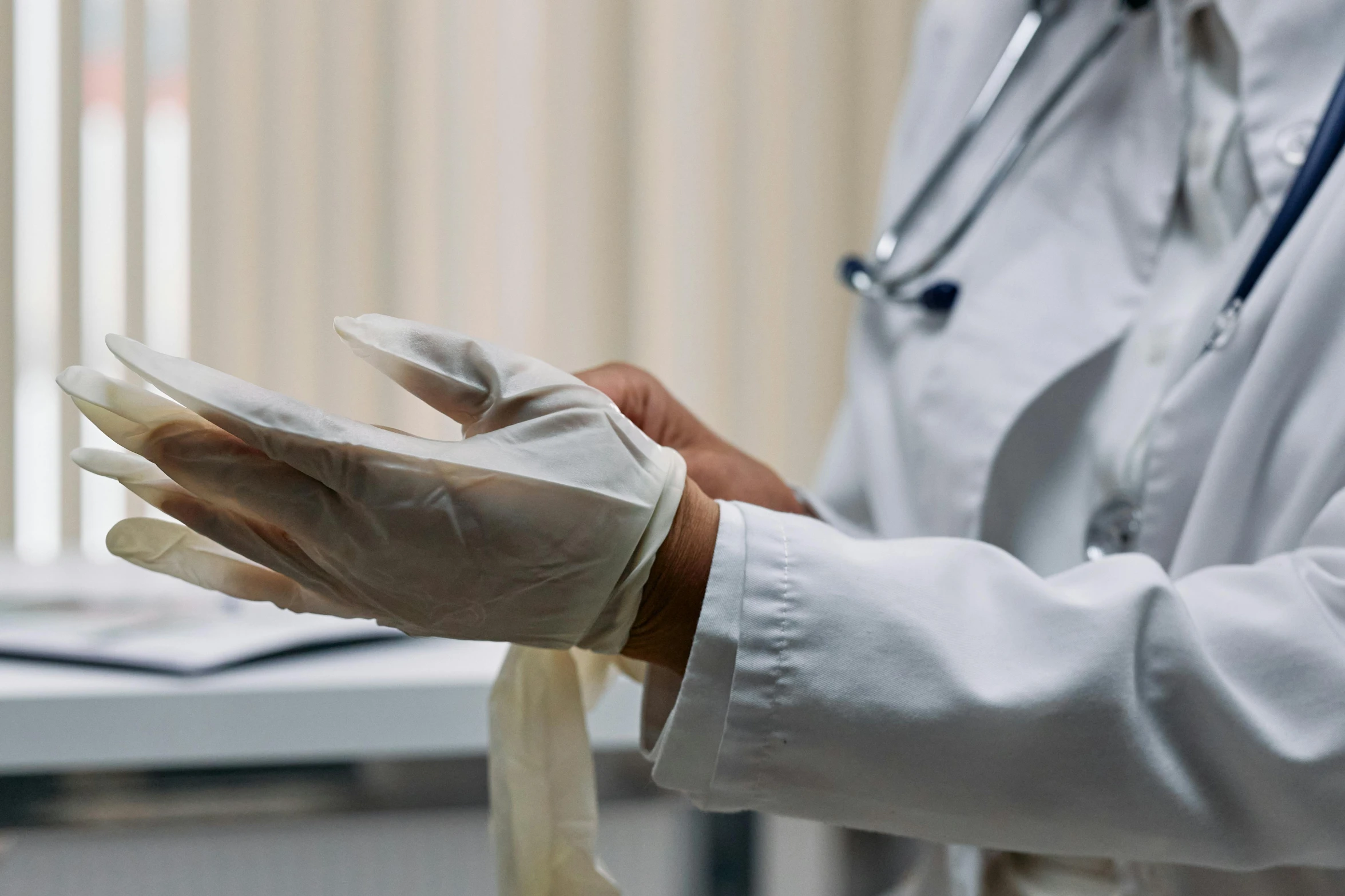 a close up of a person holding a pair of gloves, doctors office, profile image, thumbnail, white ribbon