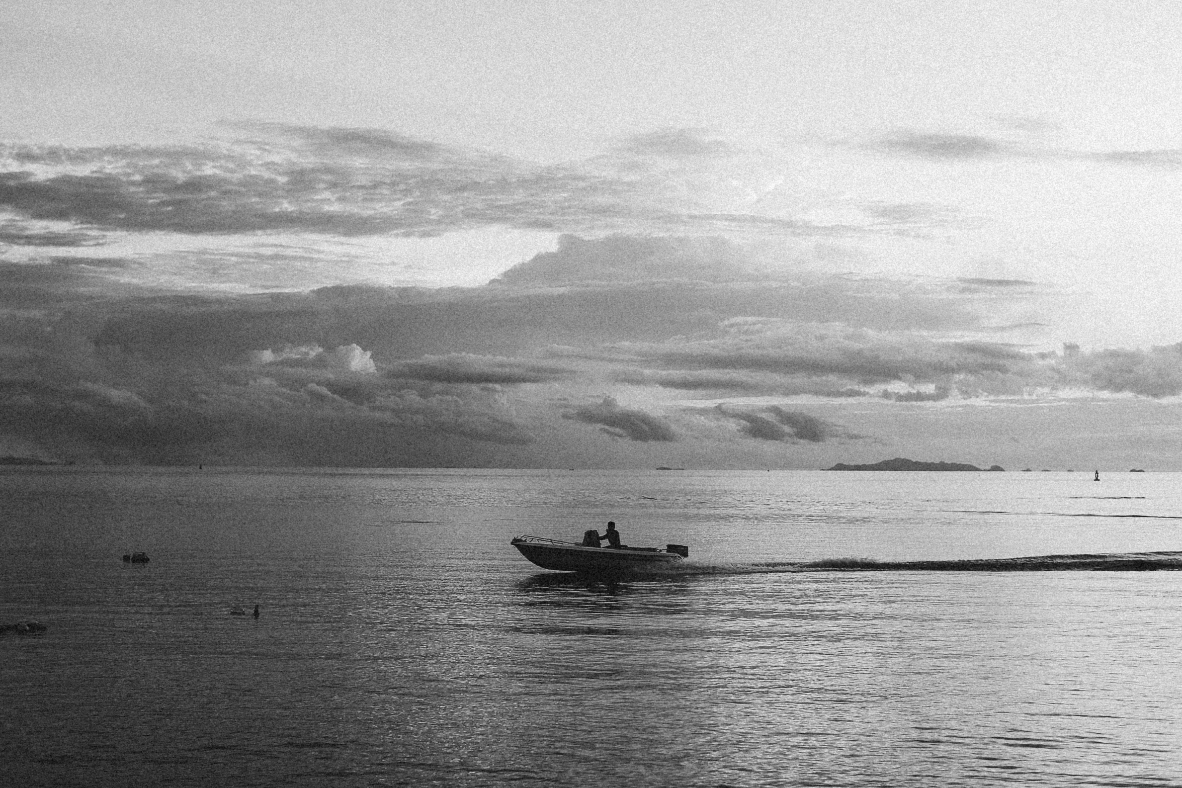 a black and white photo of a boat in the water, unsplash, sundown, sasai ukon masanao, ffffound, fisherman