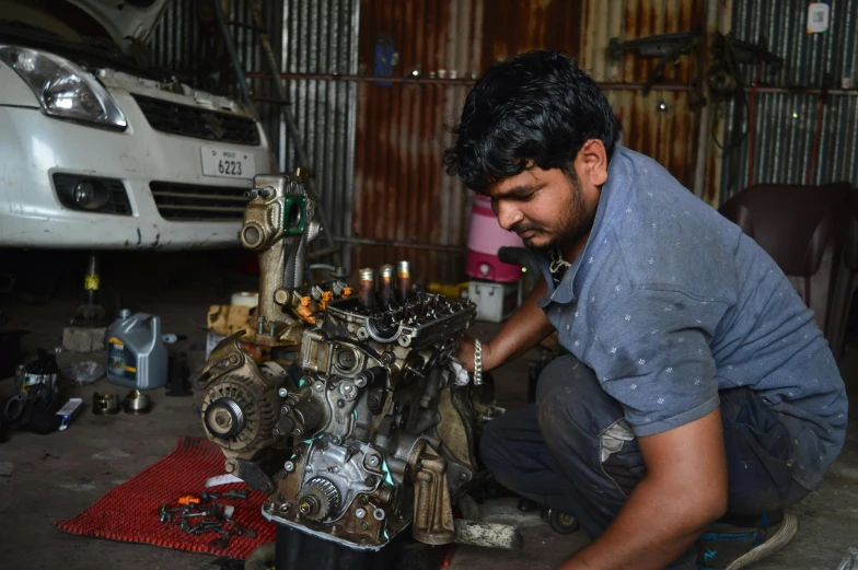 a man working on a car engine in a garage, by Rajesh Soni, auto-destructive art, 15081959 21121991 01012000 4k, around 20 yo, restoration, profile picture