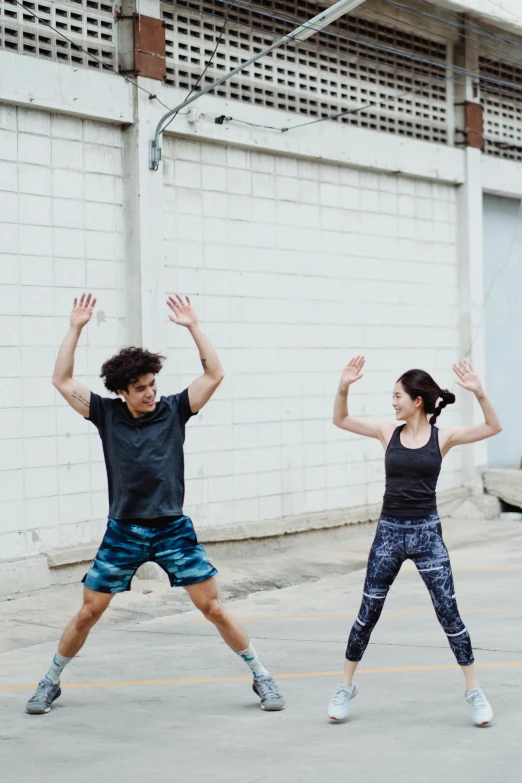 a couple of people that are jumping in the air, working out, power stance, looking at each other mindlessly, tyler edlin and natasha tan