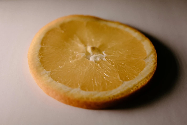 a half of a lemon sitting on top of a table, a macro photograph, by David Simpson, trending on pexels, light orange mist, circle, detailed product shot, flattened