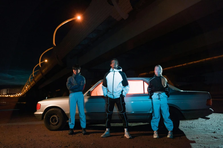 a couple of people standing next to a car, an album cover, unsplash, lyco art, chappie in an adidas track suit, posing in dramatic lighting, 3 - piece, group portrait