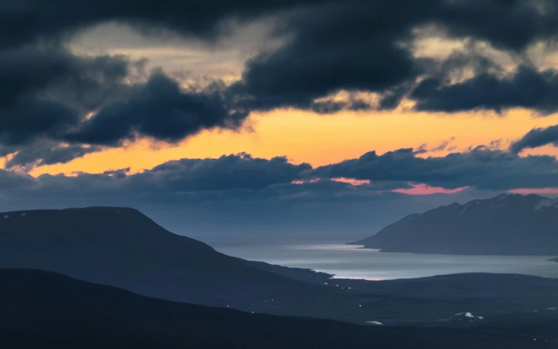 this picture has clouds in the sky above a body of water