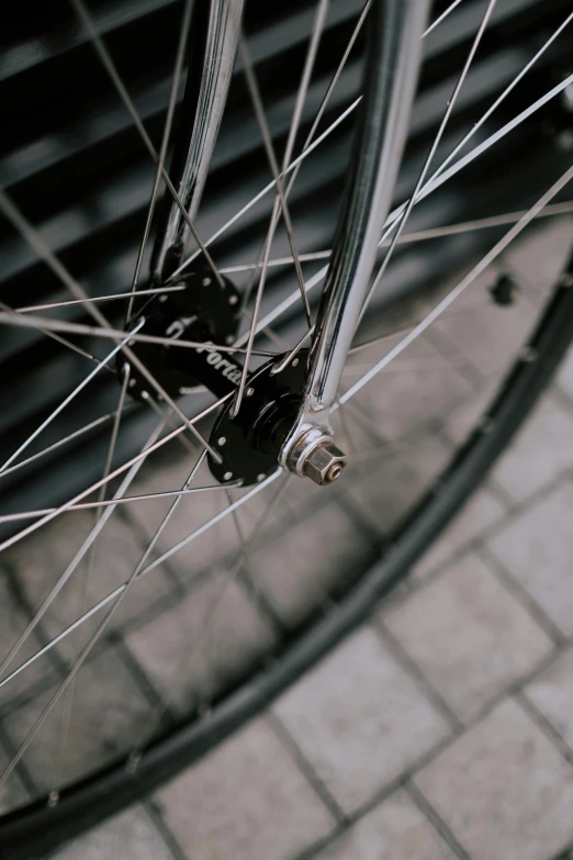a black and white photo of a bicycle wheel, colour photograph, detailed alloy wheels, a small, spiky