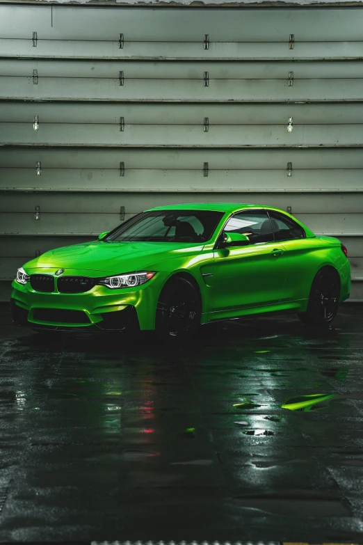 a green sports car is parked in front of a garage