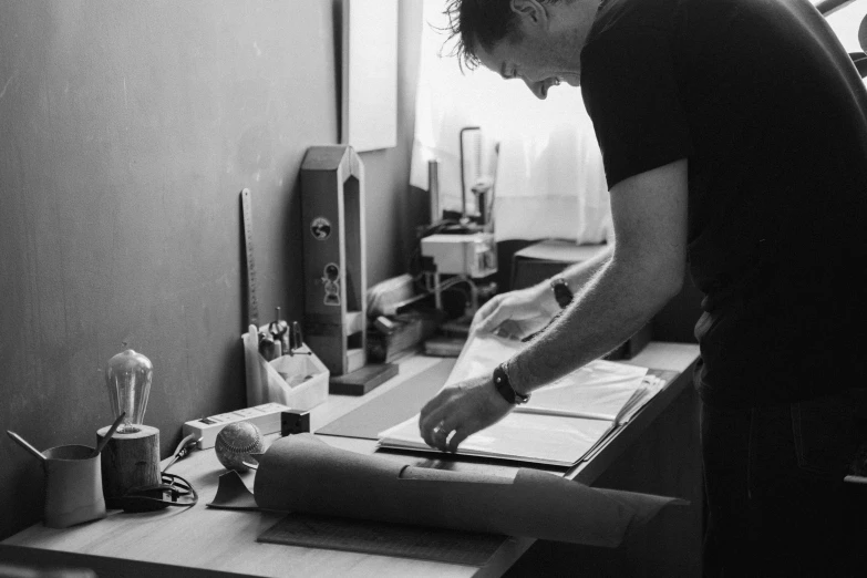 a black and white photo of a man cutting paper, a silk screen, by Caro Niederer, pexels, profile picture 1024px, instagram post, ben ridgway, peter hurley