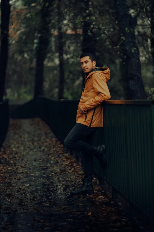 the man is standing at a park's wall with his hand on the shoulder