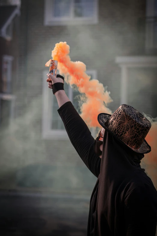 a person holding up a smoke bomb in front of a building, orange balaclava, smokey cannons, dystopian celebration, profile image