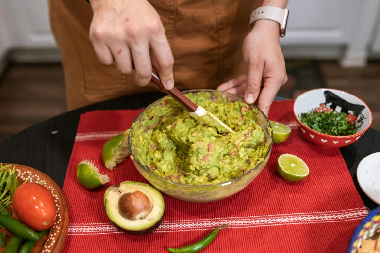 a person holding a knife over a bowl of guacamole, pexels, 🦩🪐🐞👩🏻🦳, avatar image, product shot, angled shot