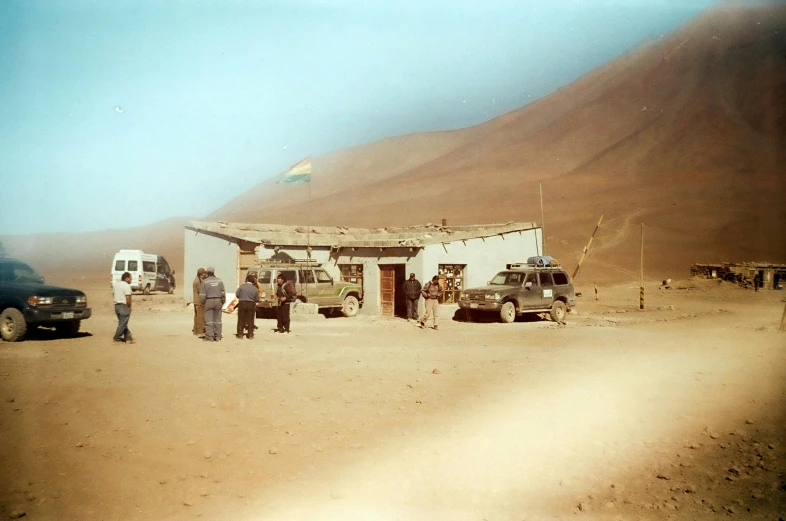 a group of people standing in front of a building, a polaroid photo, by Peter Churcher, les nabis, military outpost, andes, gas station, troops searching the area