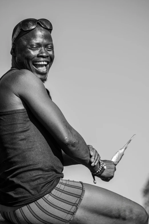 a black and white photo of a woman holding a knife, by Peter Churcher, hurufiyya, brown skin man with a giant grin, having fun in the sun, adut akech, photograph taken in 2 0 2 0