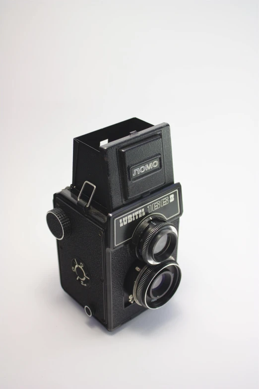 a black camera sitting on top of a white surface, by Thomas Fogarty, flickr, bauhaus, medium format. soft light, 1962 soviet, cinematic front shot, tom