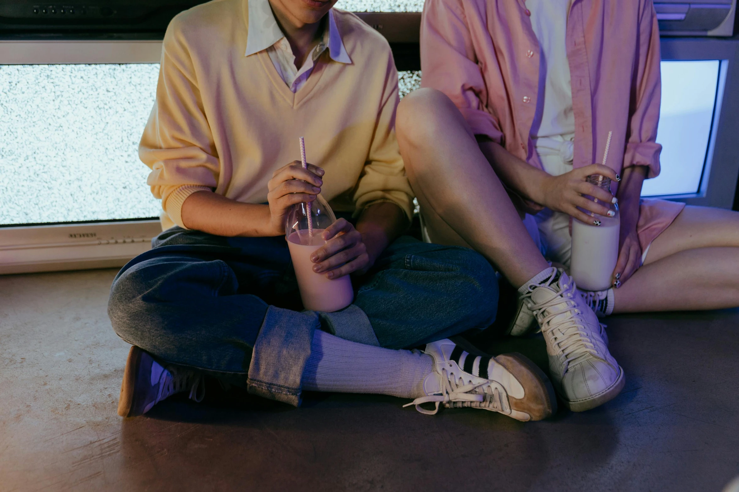 a man and a woman sitting next to each other, trending on pexels, milkshake, wearing white sneakers, bisexual lighting, federation clothing