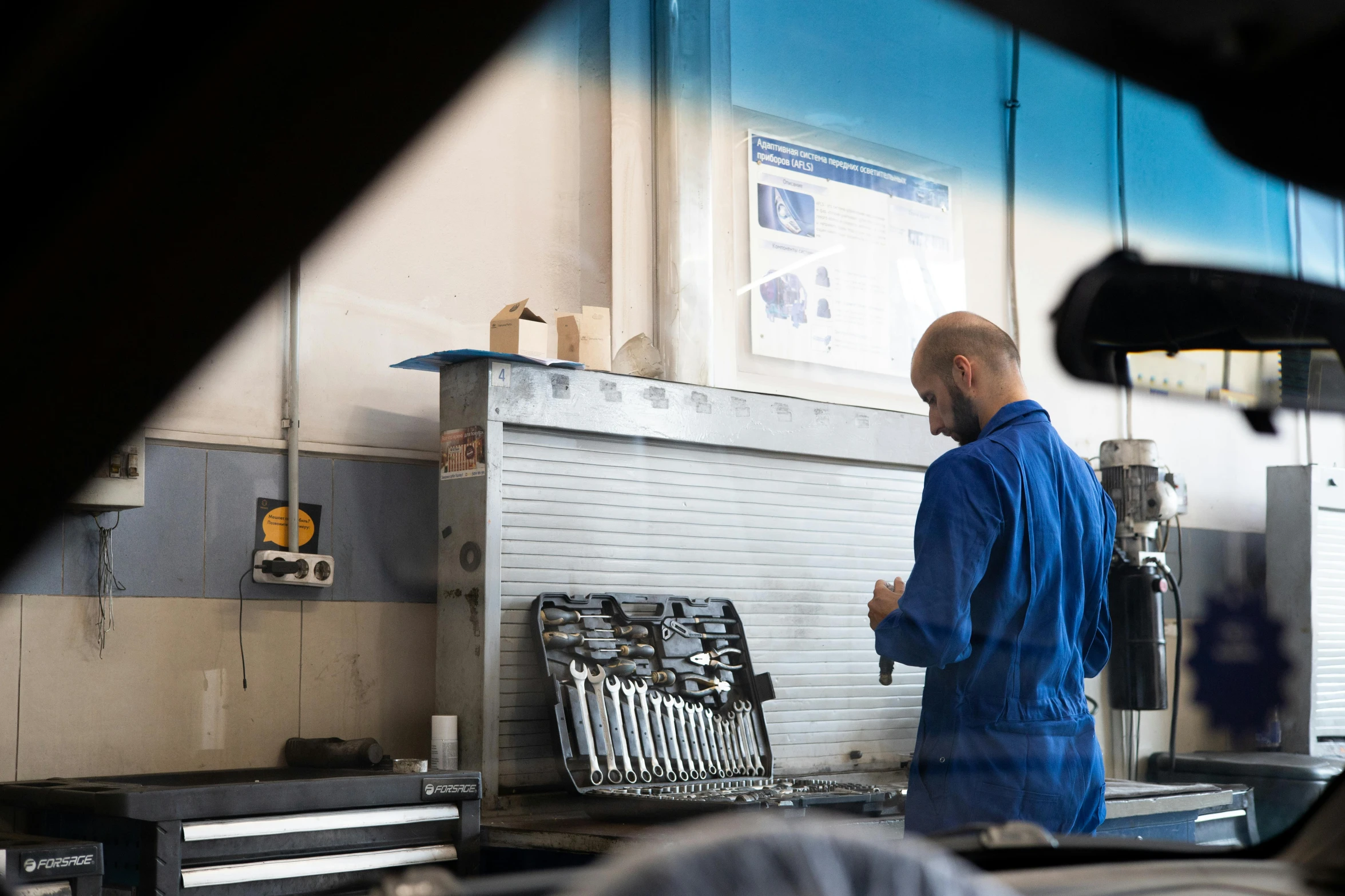 a man that is standing in front of a machine, in a workshop, profile image, attention to details, automotive