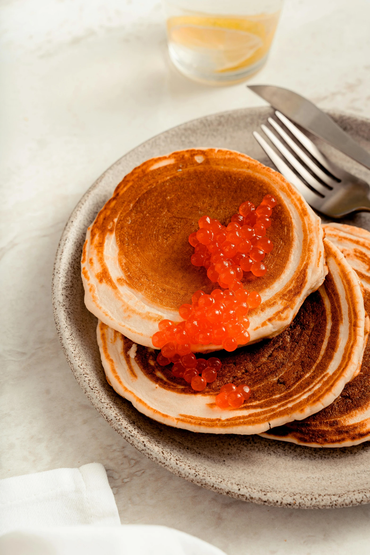 pancakes with red sauce on a plate next to a fork