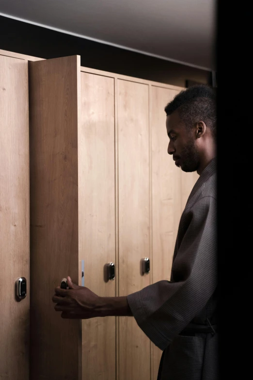 a man looking down in the door of a wood locker