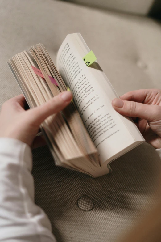 a person reading a book on a couch, pexels contest winner, annotations and scratches, vertical orientation, holding a wood piece, with fluo colored details