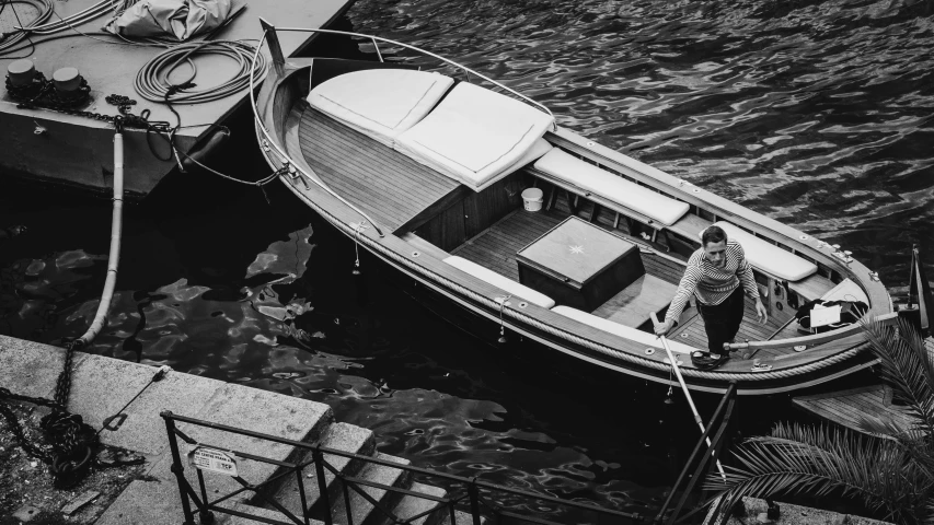 a black and white photo of a man in a boat, a black and white photo, by Giuseppe Avanzi, pexels contest winner, renaissance, wooden, 🌸 🌼 💮, a high angle shot, standing elegantly