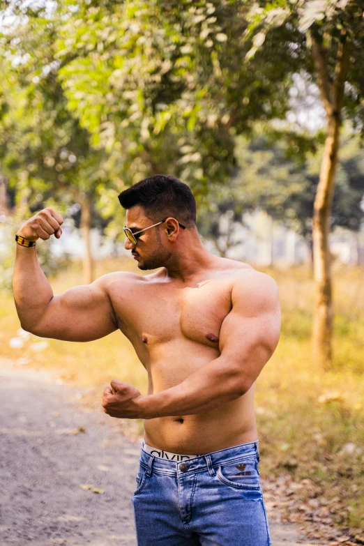 a man wearing  is flexing his muscles