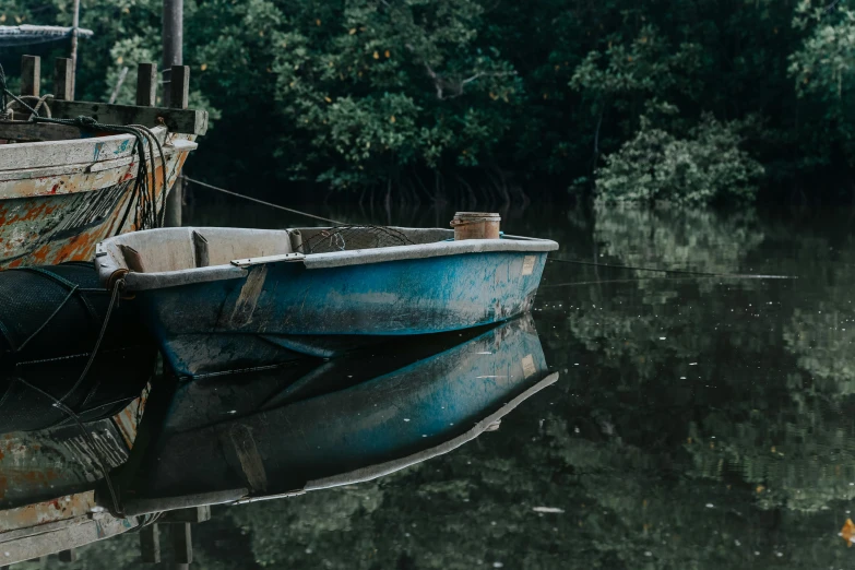 a couple of boats that are sitting in the water, by Elsa Bleda, pexels contest winner, australian tonalism, mangrove swamp, shades of blue and grey, reflective chitin, a screenshot of a rusty
