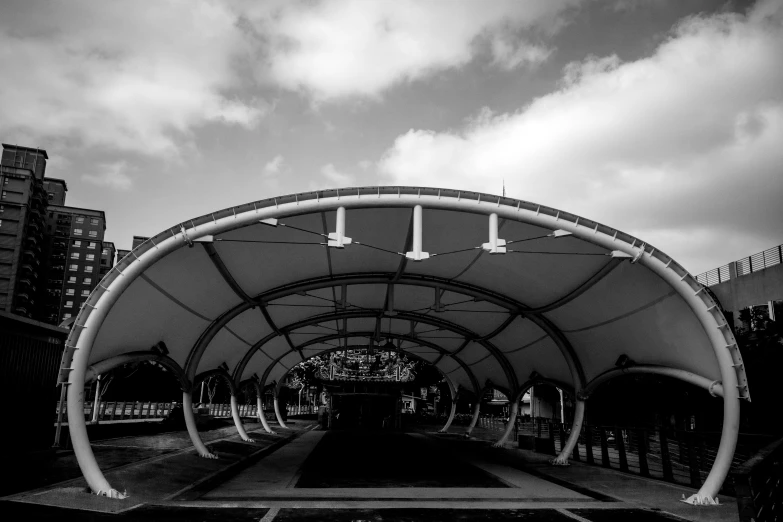 a black and white photo of a train station, visual art, canopies, singapore esplanade, outside in parking lot, street photo