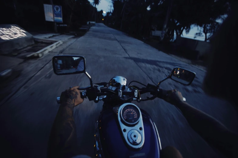 a person riding down a dark street on a motorcycle