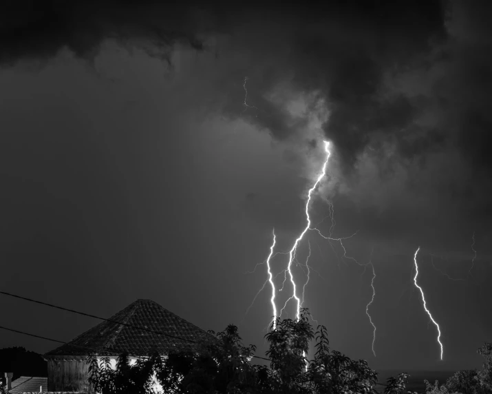 lightning hitting the roof of a house as it is about to strike