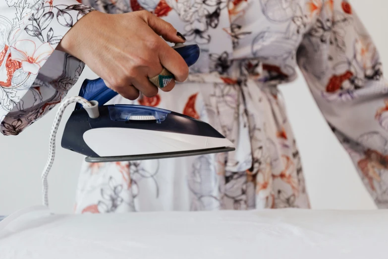 a woman ironing on an ironing board, by Julia Pishtar, pexels contest winner, wearing floral chiton, “ iron bark, profile image, thumbnail