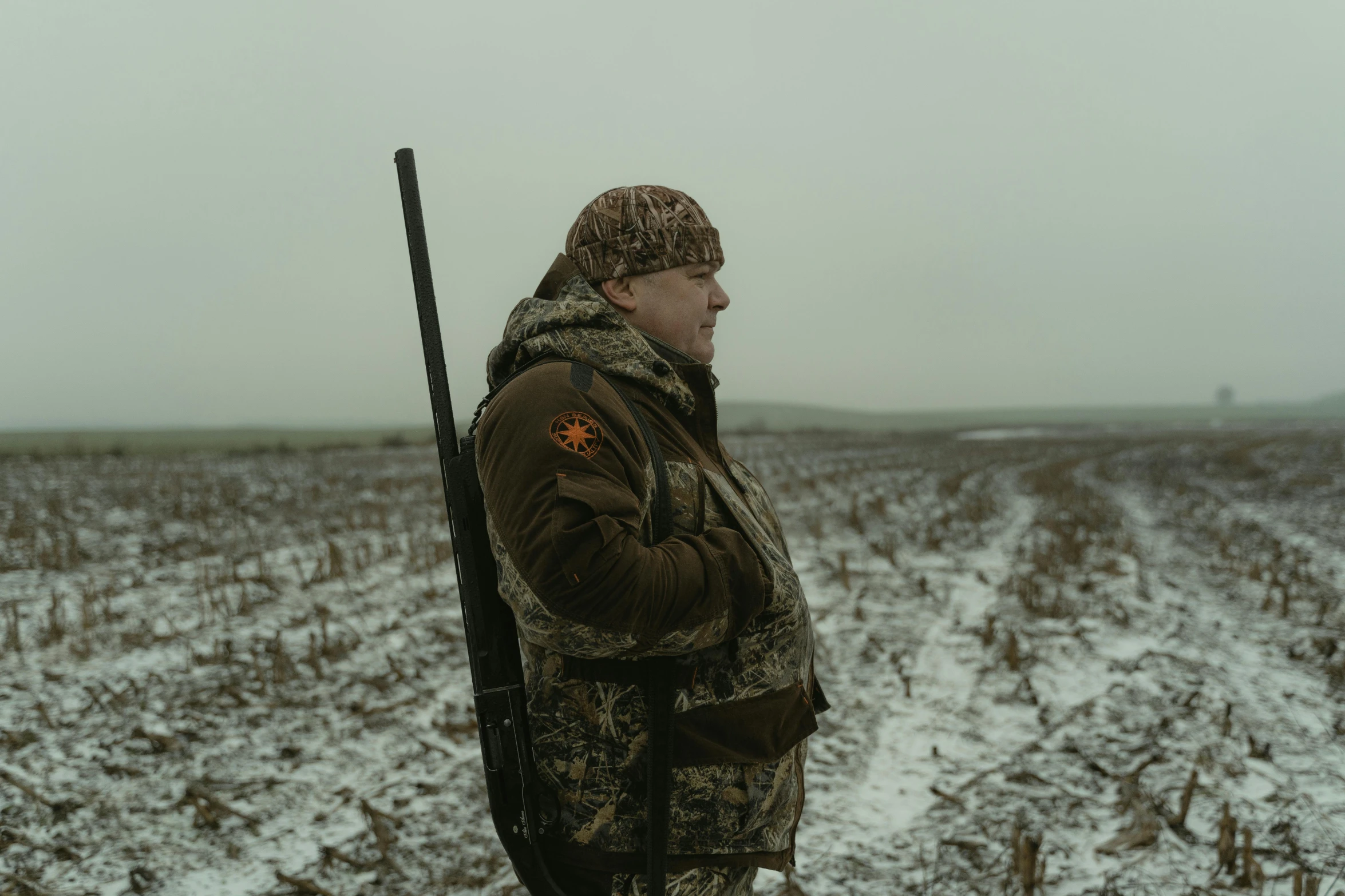 a man standing in a snowy field holding a shotgun, pexels contest winner, southern slav features, gazing off into the horizon, high grain, shot on hasselblad