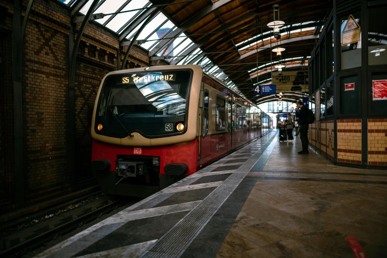 a red and white train pulling into a train station, by Kristian Zahrtmann, pexels contest winner, art nouveau, light tan, subway, brown, germany. wide shot